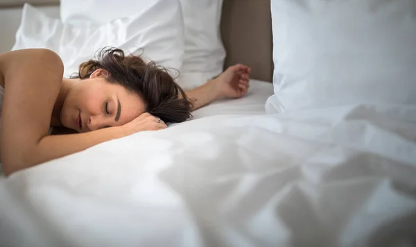 Mooie jonge vrouw slapen op bed — Stockfoto
