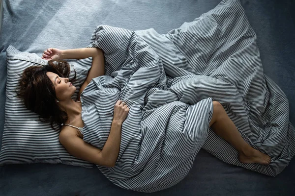 Красивая, молодая женщина в постели, крепко спит — стоковое фото