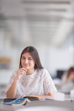 Güzel, genç üniversite öğrencisi kütüphanede bir kitap arıyorum