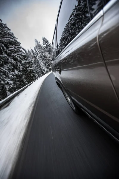 Carro em movimento rápido em uma estrada de neve alpina de inverno — Fotografia de Stock