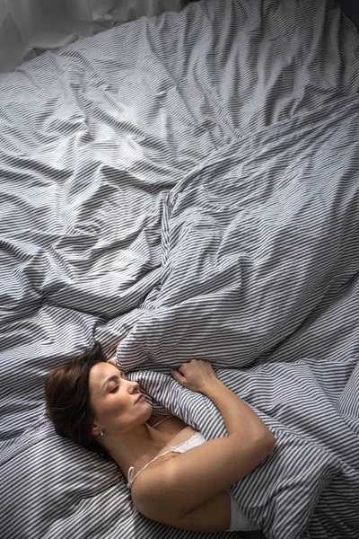 Όμορφη, νεαρή γυναίκα στο κρεβάτι της, κοιμάται βαθιά. — Φωτογραφία Αρχείου
