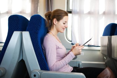 trenle seyahat ederken onun tablet bilgisayar kullanan genç kadın