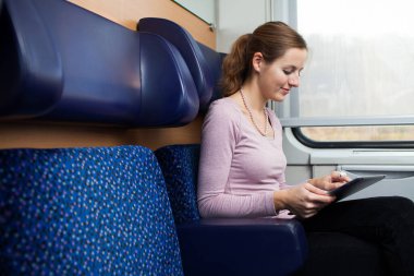 trenle seyahat ederken onun tablet bilgisayar kullanan genç kadın