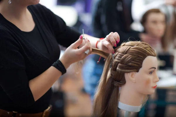 Красивая студентка-парикмахер тренируется на голове ученика — стоковое фото