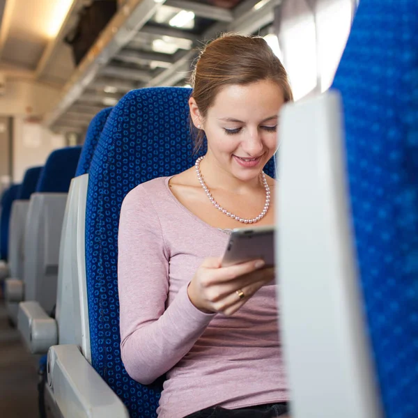 Jovem mulher usando seu computador tablet enquanto viaja de trem — Fotografia de Stock