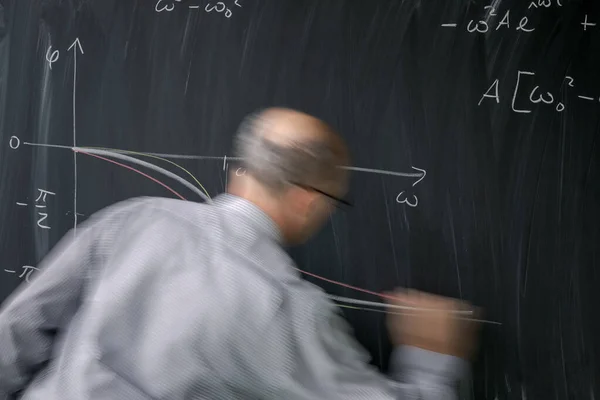 Math teacher drawing   fuction graph on a blackboard during math — Stock Photo, Image