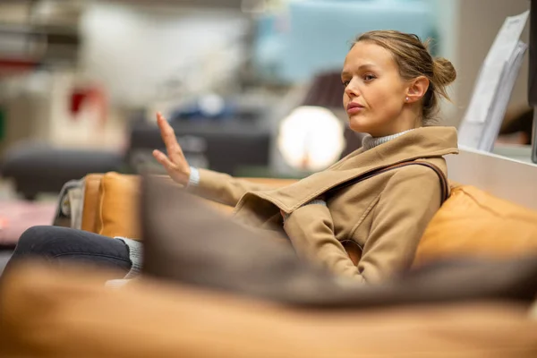 Hübsche, junge Frau bei der Auswahl der richtigen Möbel — Stockfoto