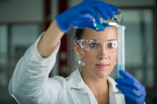 Investigadora feminina que realiza investigação científica num laboratório — Fotografia de Stock
