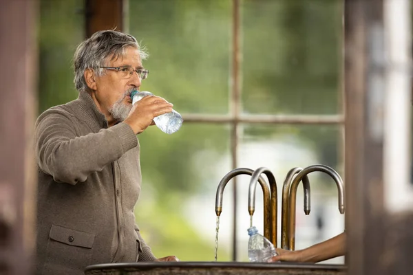 Stilig Senior Man Dricker Mineralvatten Ett Spa Kurort Åtnjuter Dess — Stockfoto