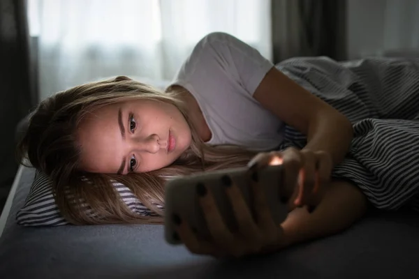 Söt Ung Kvinna Sover Sin Säng Med Sin Mobiltelefon Nära — Stockfoto