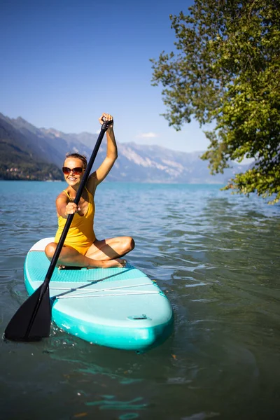Sup站起来划桨板的概念 美丽的年轻女子划桨板在一个可爱的湖上温暖的午后微光 从水下拍摄 — 图库照片