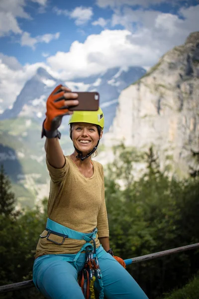 かなり 女性はフェラータ経由で登る スイスアルプスの岩の上に登る — ストック写真