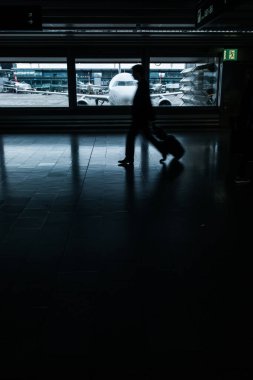 Havaalanı rush: (hareket bulanık görüntü; renk tonlu görüntü bir koridor yürüyüş onların valiz grubu)