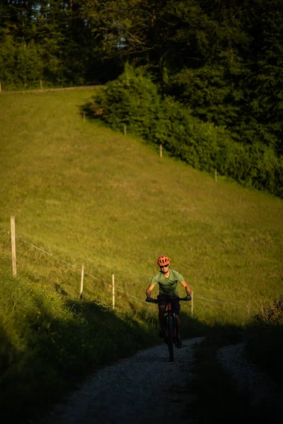 Handsome young man biking on a mountain bike enjoying healthy active lifestyle outdoors in summer (shallow DOF)