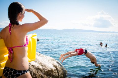 Genç adam eğleniyor ve denize dalıyor