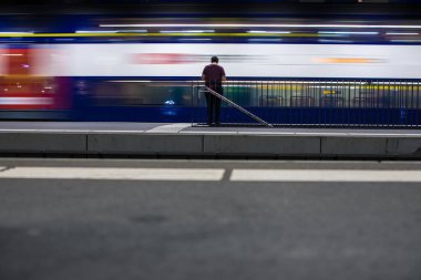 Hareket halindeki insanlar hızlı hareket eden trenleri bulanıklaştırdı (renk tonlu görüntü))