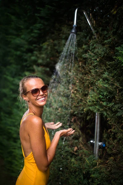 美丽的年轻女子在户外洗澡 迷人的年轻女子在游泳后阳光灿烂的炎热天气里 独自享受着黄色的淋浴 热与点心的概念 — 图库照片
