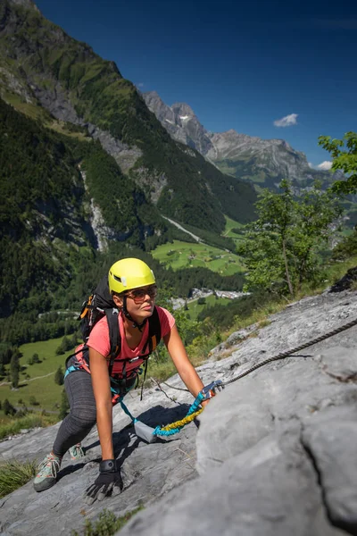 漂亮的女攀登者爬上了一条穿越的雪貂 在瑞士阿尔卑斯山的岩石上攀爬 — 图库照片