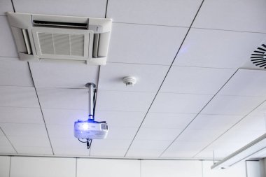 Bir konferans odasının tavanında beyaz bir projektör / modern sınıf (renk tonlu resim)