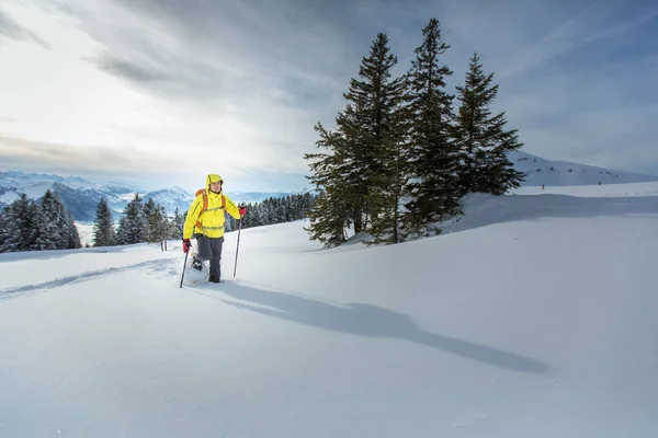 高い山の中で雪の多い冬の天気を楽しんでいる若い男 — ストック写真