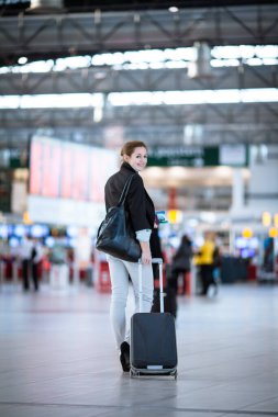 Havaalanında güzel genç bayan yolcu (sığ DOF; renk tonlu resim)