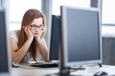 Masaüstü bilgisayar ekranına bakan güzel, bayan öğrenci sınav sonuçları hakkında tatsız haberler öğreniyor. Üniversite / ofis / okul kavramı