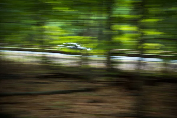 汽车在森林中的州际公路上飞驰而去 — 图库照片