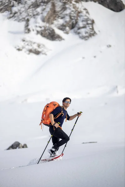 冬季运动 年轻人穿着雪鞋行走高山 覆盖着大雪 背景中有选择地集中在高山上 — 图库照片