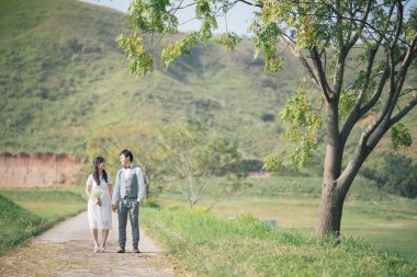 Birbirine aşık çiftler el ele tutuşur ve doğada birlikte yürürler.  