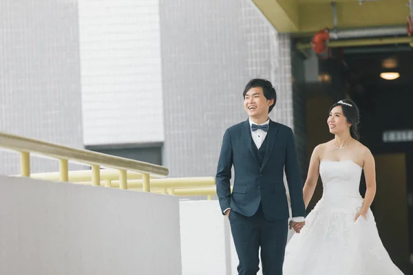 幸福的新郎新娘牵着手站在大楼附近 婚礼的理念 — 图库照片