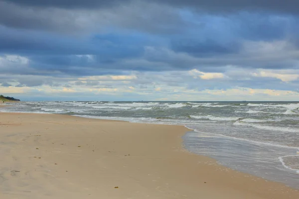 Дикий песчаный пляж под облачным небом заката — стоковое фото