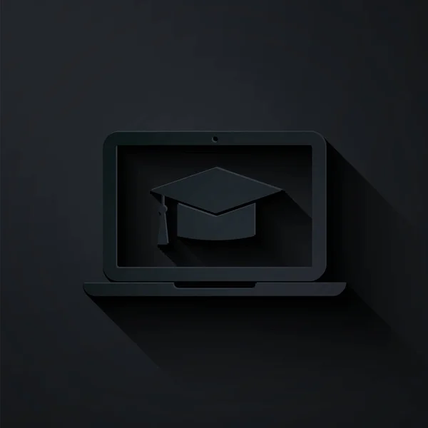Papperssnitt Graduation cap på skärmen laptop ikon isolerad på svart bakgrund. Nätbaserad inlärning eller e-lärande. Papperskonst. Vektor Illustration — Stock vektor