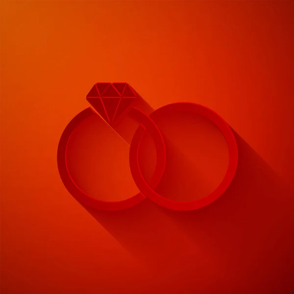 Corte de papel Anillos de boda icono aislado sobre fondo rojo. Signo de joyería de novia y novio. Icono del matrimonio. Anillo de diamantes. Estilo de arte de papel. Ilustración vectorial — Archivo Imágenes Vectoriales