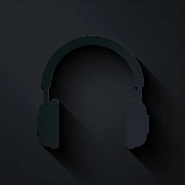 Papel corte Headphones ícone isolado no fundo preto. Auriculares assinados. Objeto conceitual para ouvir música, serviço, comunicação e operador. Estilo de arte de papel. Ilustração vetorial —  Vetores de Stock