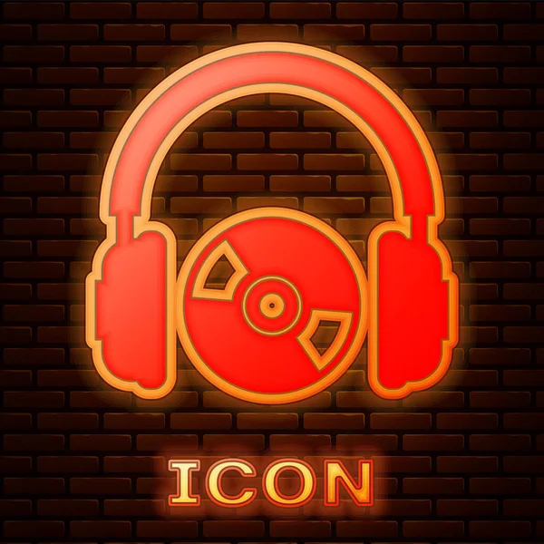 Glowing neon Headphones and CD or DVD icon isolated on brick wall background. Earphone sign. Compact disk symbol. Vector Illustration — Stock Vector