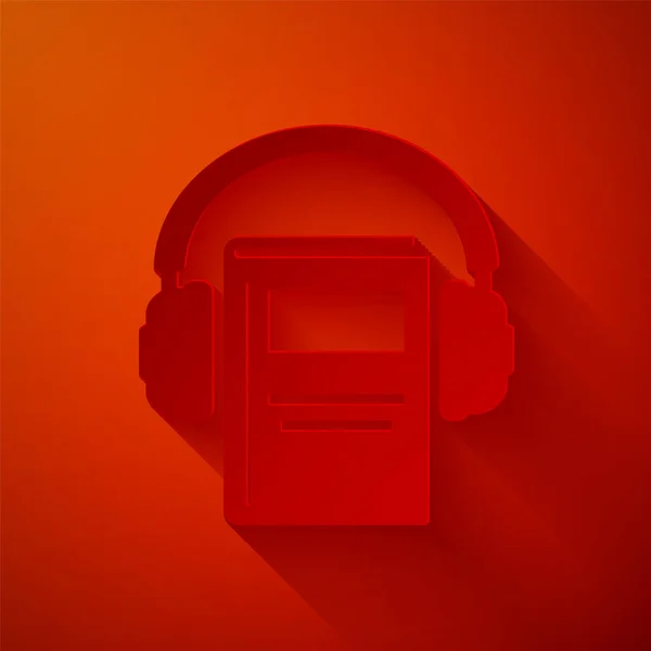 Corte de papel Ícone de livro de áudio isolado no fundo vermelho. Livro com auscultadores. Sinal de guia áudio. Conceito de aprendizagem online. Estilo de arte de papel. Ilustração vetorial — Vetor de Stock