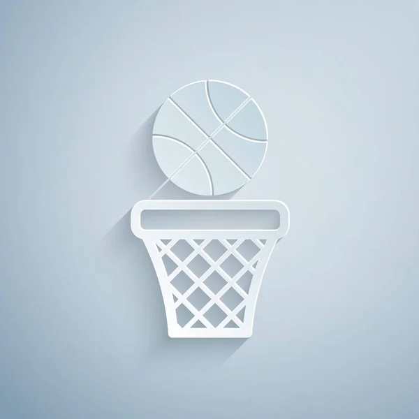 Papiergeschnittener Basketballball und Basketballsymbol isoliert auf grauem Hintergrund. Ball im Basketballkorb. Papierkunst. Vektorillustration — Stockvektor