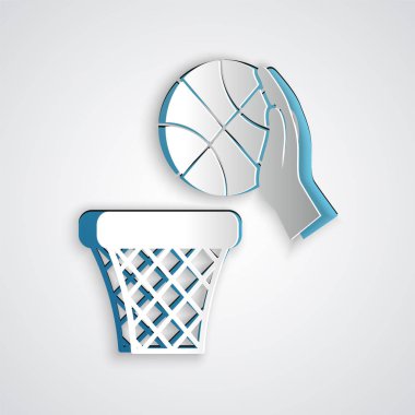 Kağıt kesiği El basketbol topu ve basket ikonu gri arka planda izole edilmiş. Basketbol potasında top. Kağıt sanatı tarzı. Vektör İllüstrasyonu