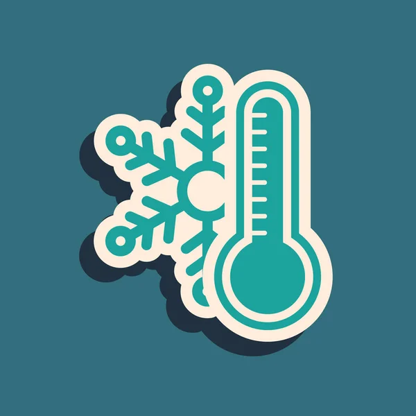 Grön termometer med snöflinga ikon isolerad på blå bakgrund. Lång skuggstil. Vektor Illustration — Stock vektor