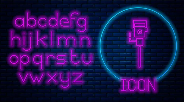 Zářící neon konstrukce sbíječka ikona izolované na pozadí cihlové zdi. Neonová světlá abeceda. Vektorová ilustrace — Stockový vektor
