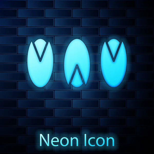 Leuchtende Neon-Pistazien-Ikone isoliert auf Backsteinwand Hintergrund. Vektorillustration — Stockvektor