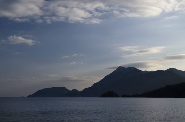 Arkasında bir dağ olan karanlık kumsal.