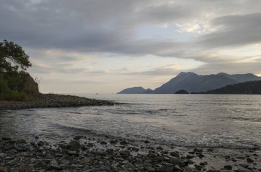 Türkiye 'nin Akdeniz kıyısındaki Akdeniz kıyısında gün batımında Türkiye' nin Akdeniz kıyısındaki çakıl taşı plajı