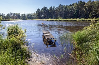 Small wooden pier on a lake hidden in forest near Nakielno, small village West Pomeranian Voivodeship of Poland clipart