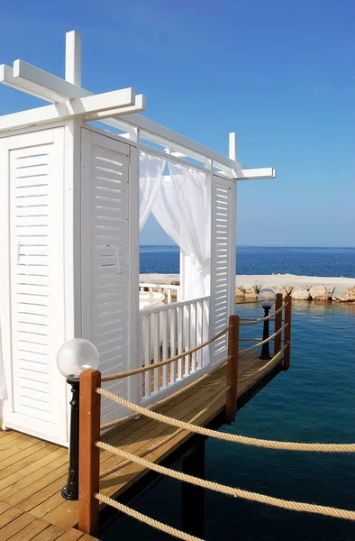 Witte strand tent op een achtergrond van blauwe zee in hotel. — Stockfoto