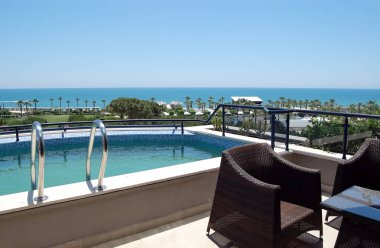 Küçük havuz ve plajda Türk otelin balkonundan görünümü.