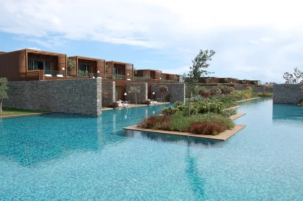 Vista das villas elegantes, piscina azul e canteiros de flores em luxo — Fotografia de Stock