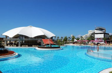 Mavi havuz ve bar Türk h büyük beyaz şemsiye altında görünümü