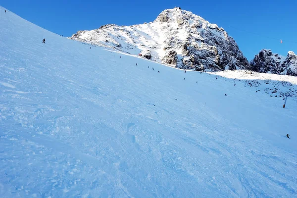 Skiers on mountain slope in winter sunny day in High Tatras. — Stock Photo, Image