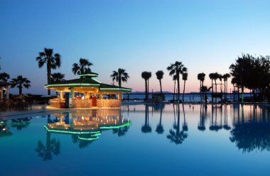 Türk h gün batımında Havuzu, havuz bar ve palmiye ağaçları